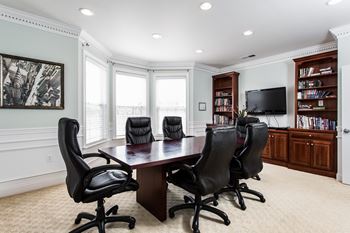 A conference room with a table and chairs and a television